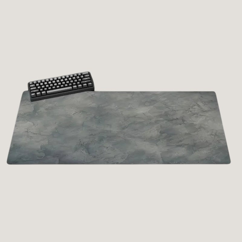 Large gray Melora desk mat with a textured pattern and black keyboard on a desk