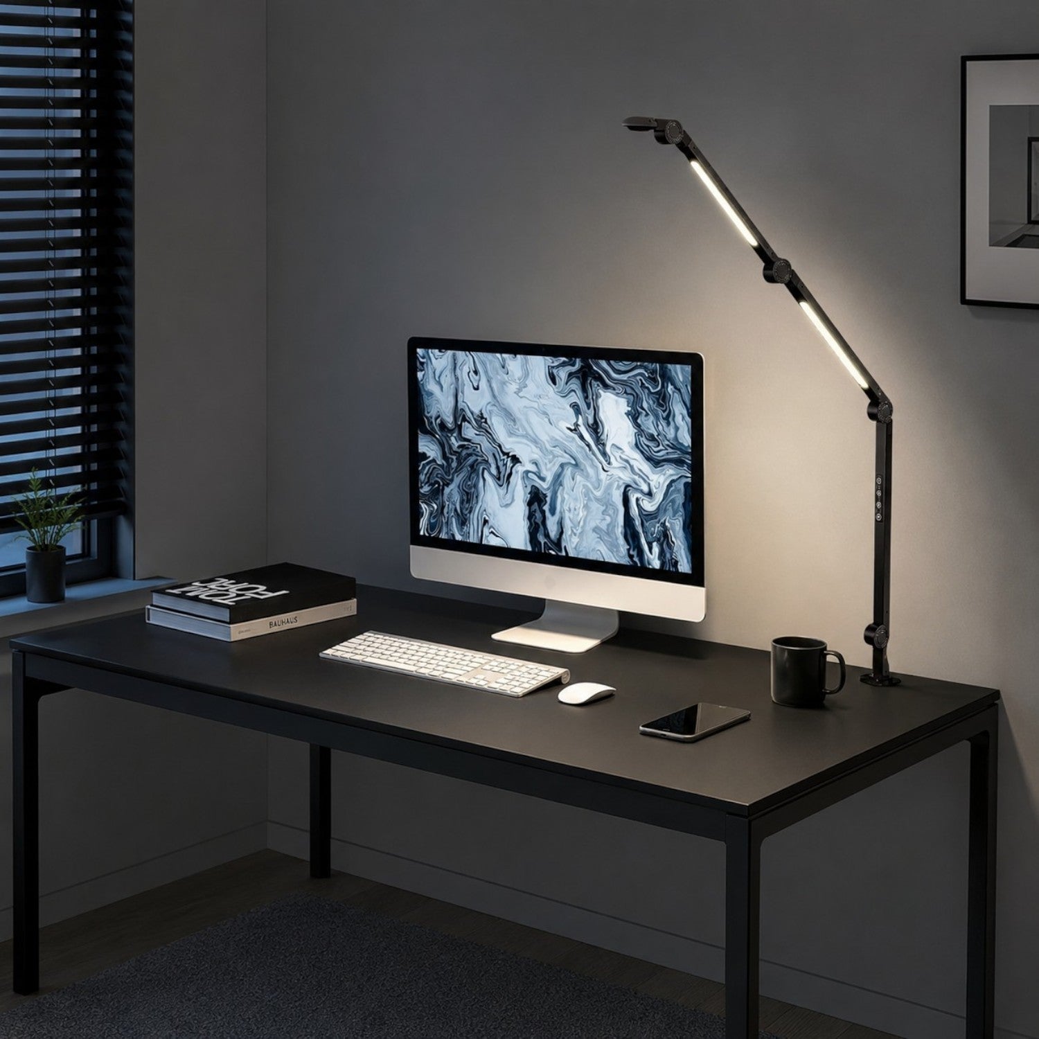 Woman working at a computer with a black aluminum Melora swing-arm desk lamp on the desk