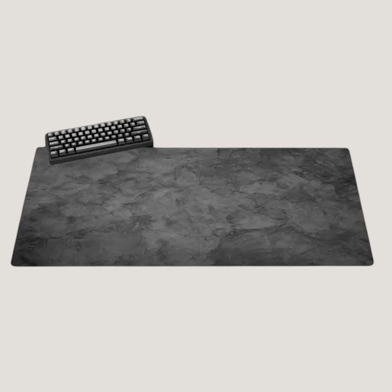Gray Melora XL desk mat with a stone-look texture and black keyboard on a desk
