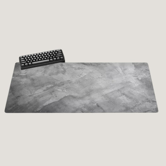 Gray Melora XL desk mat with a concrete-look texture and black keyboard on a desk